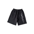 Oversized streetwear shorts in black with a stylized cursive signature design.