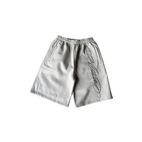 Oversized streetwear shorts in grey featuring a cursive signature design down the side.